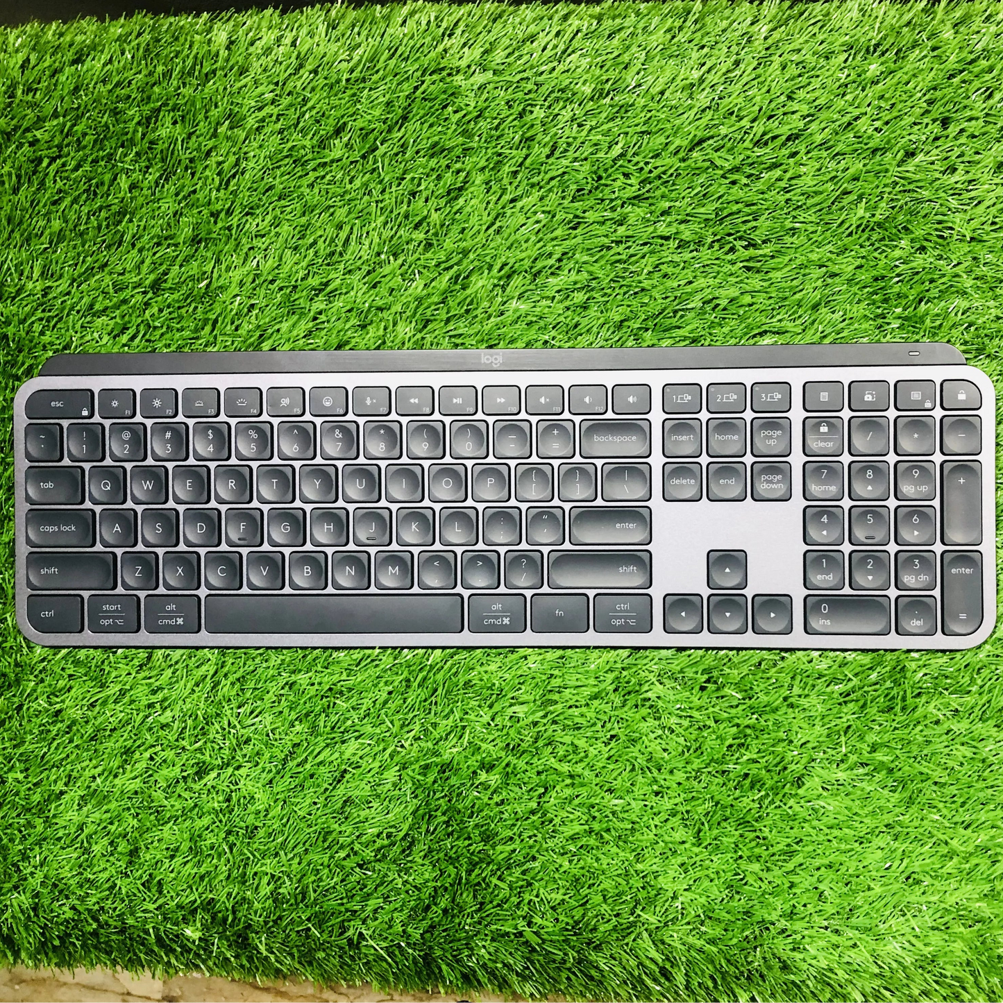 Keyboard and mouse set on a green grass-like surface