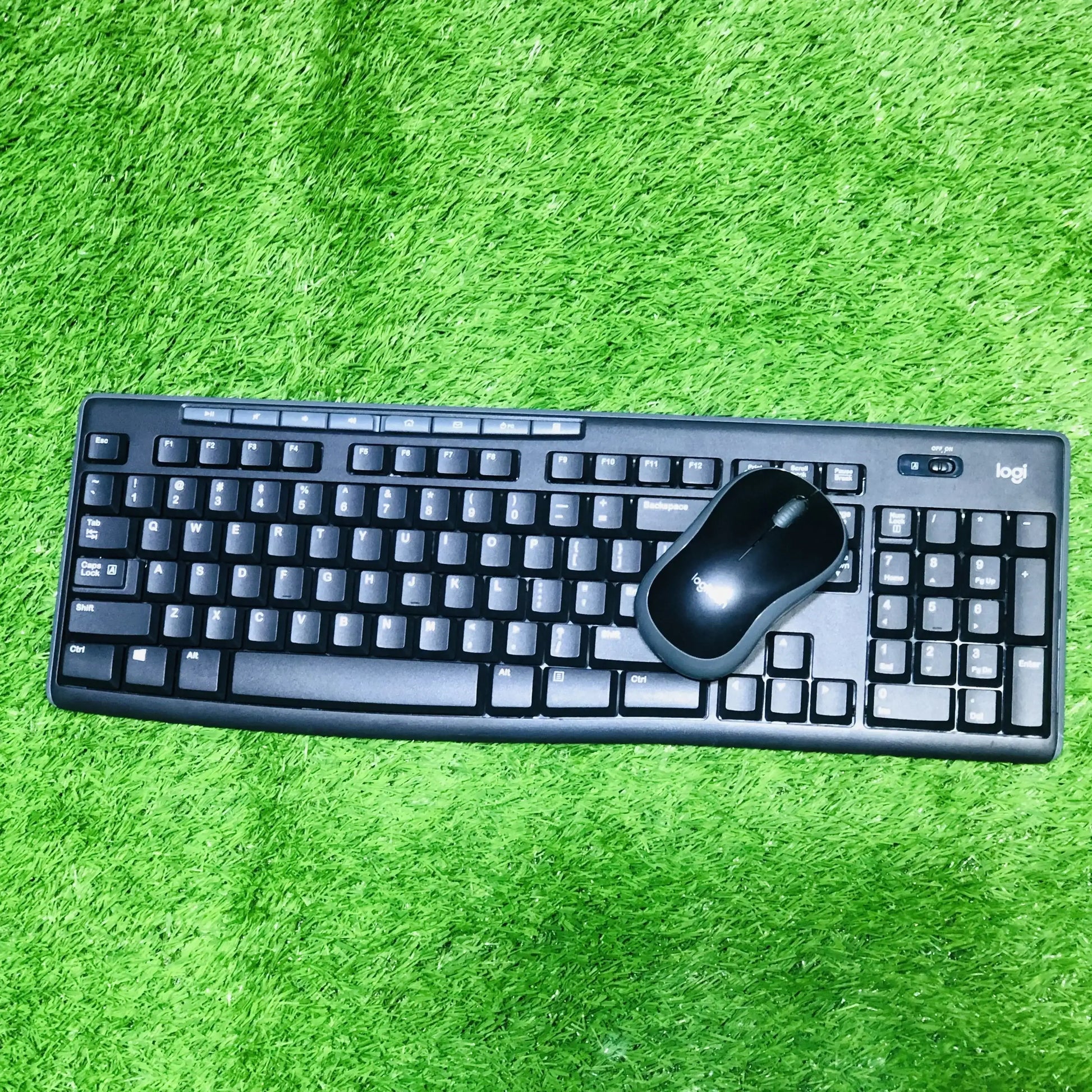 Black keyboard and mouse set on a green textured surface