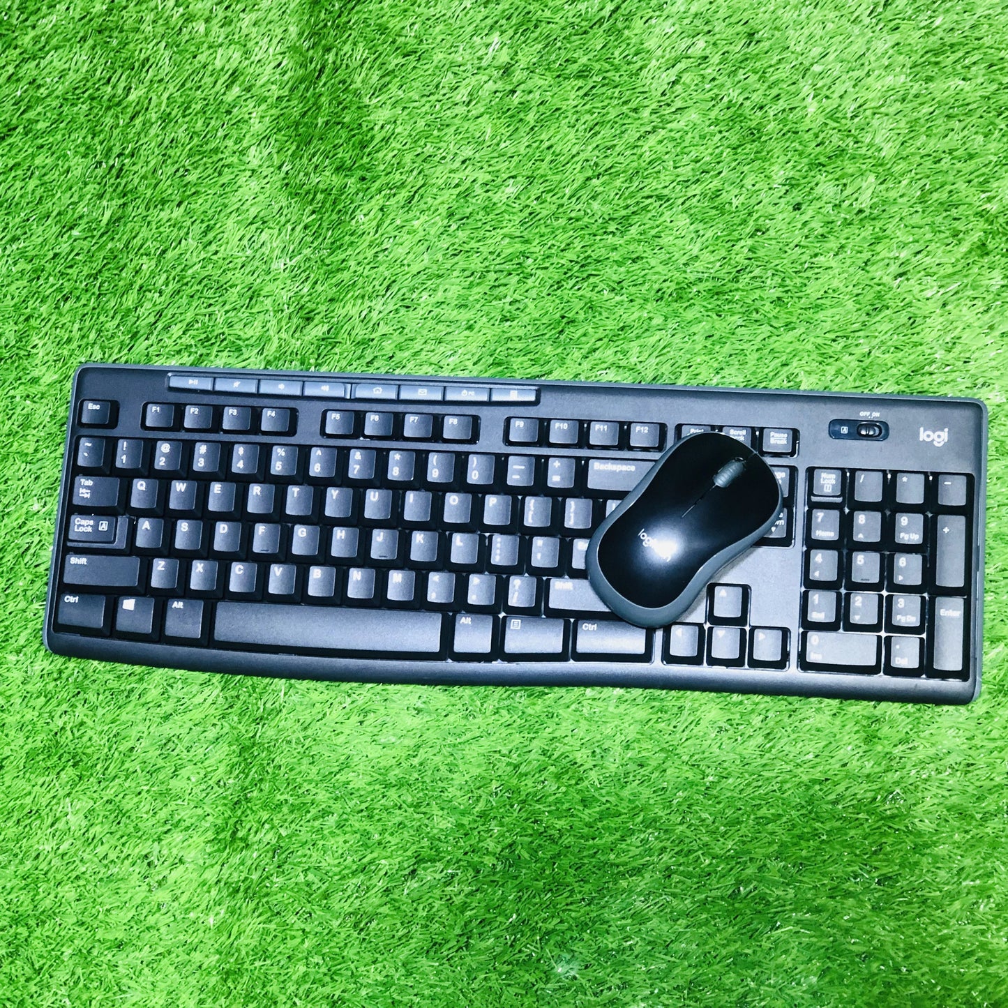 Black keyboard and mouse set on a green textured surface