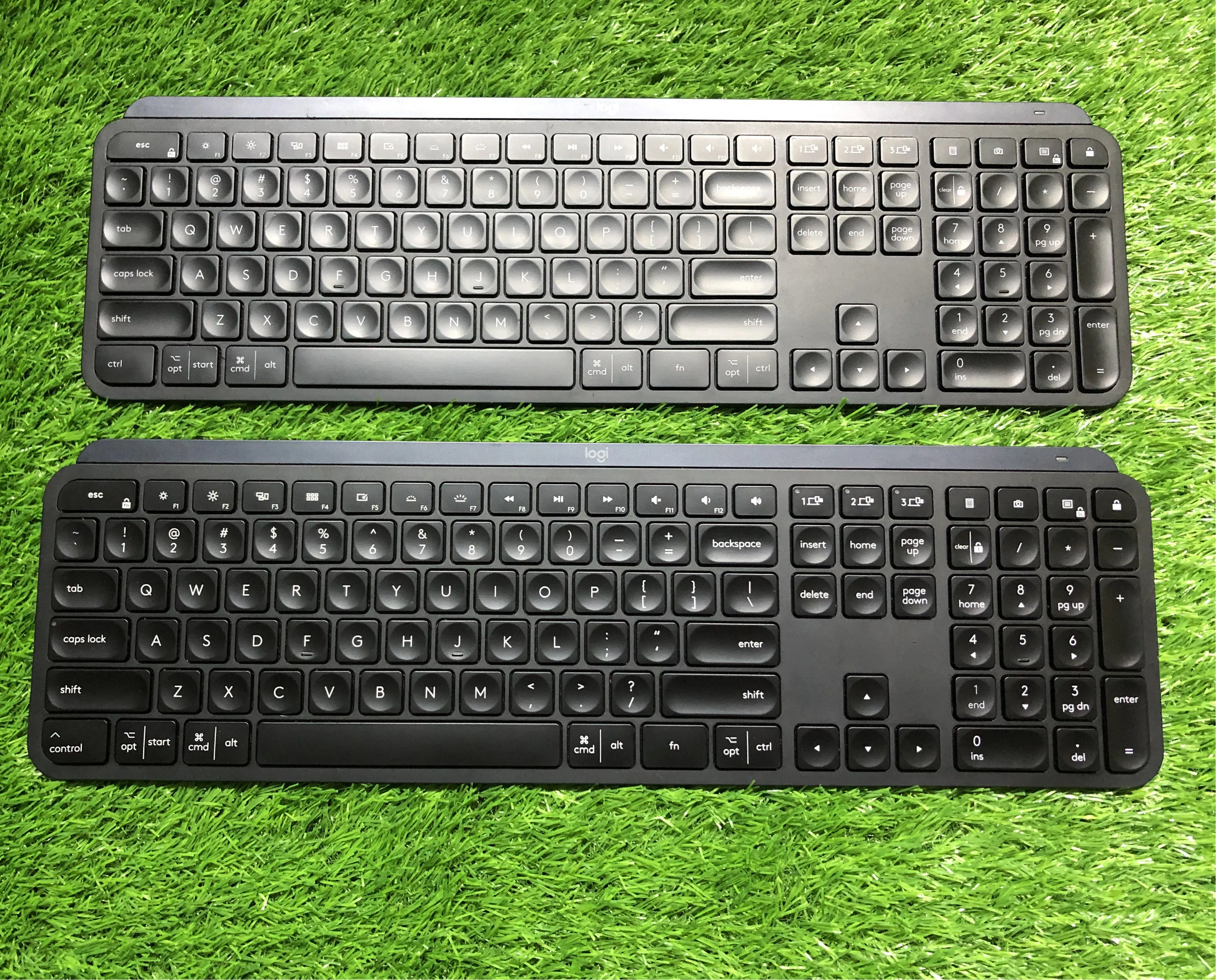 Two black keyboards on a grassy background