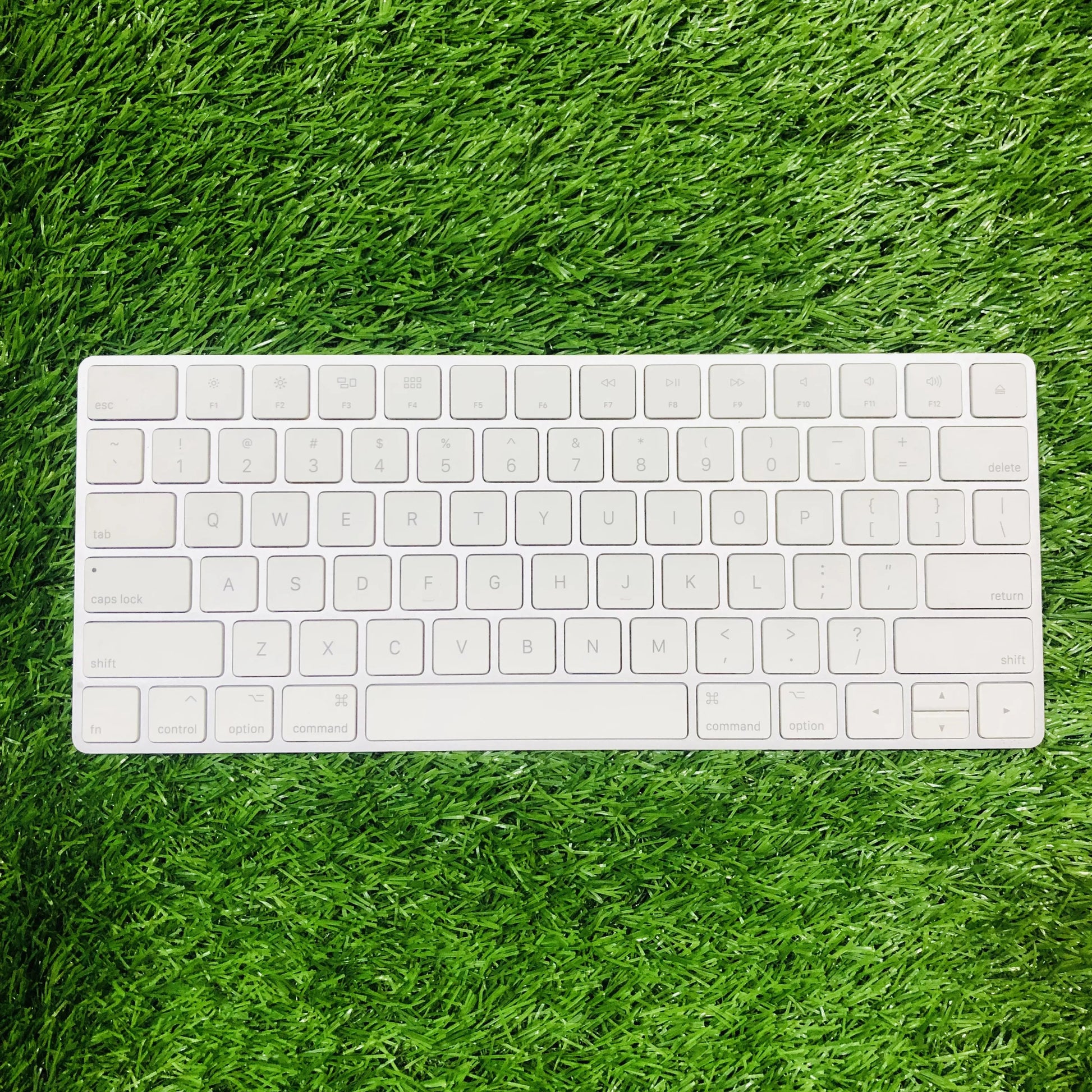 White keyboard on a green grass-like surface